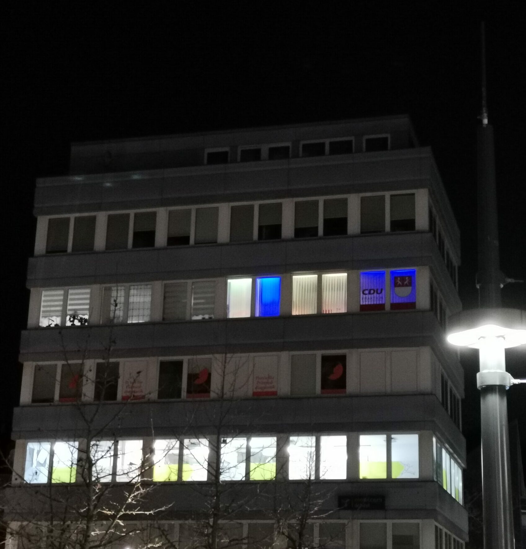 Das Fraktionsbüro leuchtet abends in den Landesfarben der Ukraine.